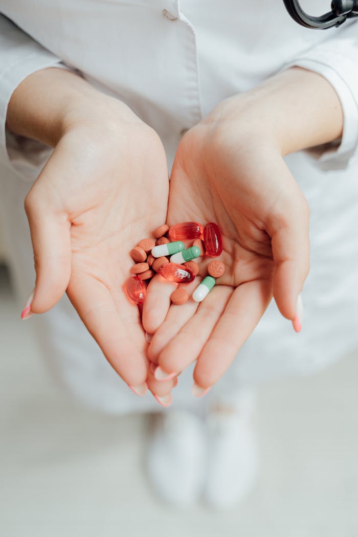about-03 Close-up of a person holding various pills and capsules in their hands, symbolizing healthcare and medicine.
