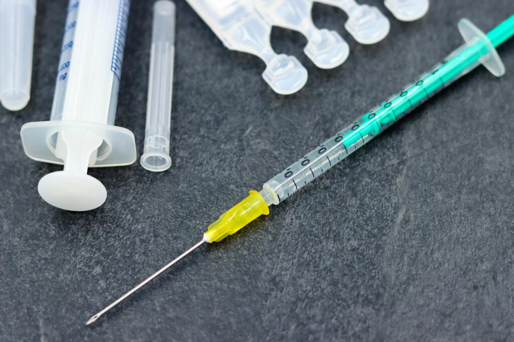 Detailed image of a syringe and medical supplies, ideal for healthcare and vaccination themes.