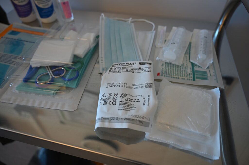 Close-up of various medical supplies on a sterile table in a healthcare setting.